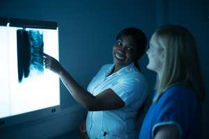 Student smiling as they point something out on an x-ray